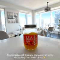 Jar of sea moss gel on a kitchen counter with a cityscape view