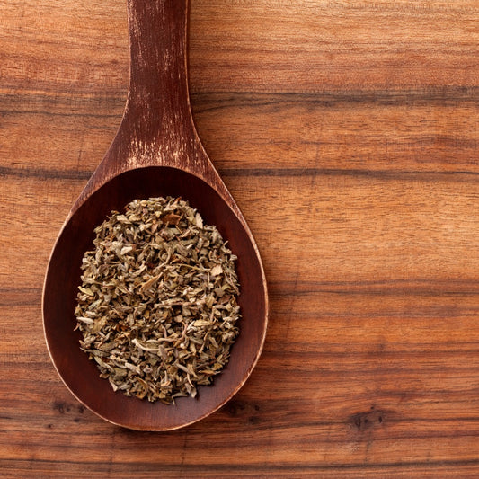 Organic damiana herb displayed in a wooden spoon on a rustic wooden background
