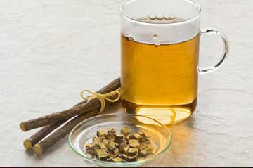 Dried licorice root and a cup of tea, perfect for those looking to buy licorice root online
