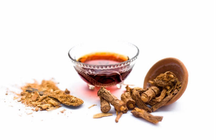 Sarsaparilla root tea in a glass bowl with dried roots and powdered sarsaparilla, perfect to buy sarsaparilla root tea