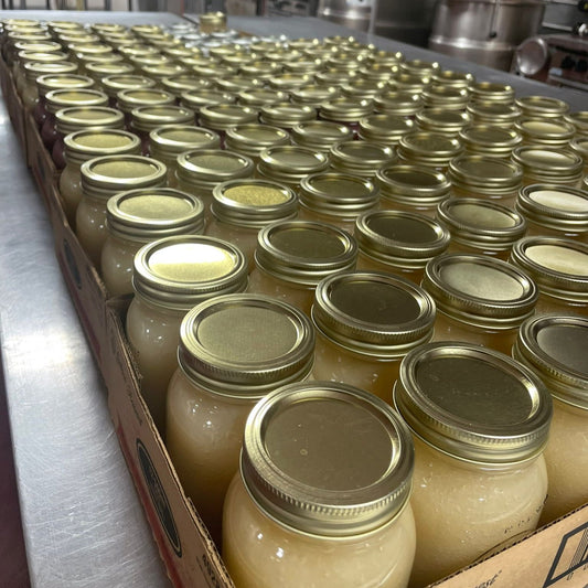 Bulk jars of wholesale sea moss gel arranged neatly on a production table